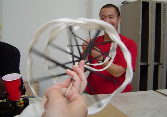 Graduate student Adam Feng plays with spiral-shaped Kinetic Sculpture