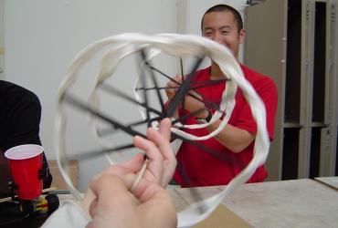 Graduate student Adam Feng plays with spiral-shaped Kinetic Sculpture